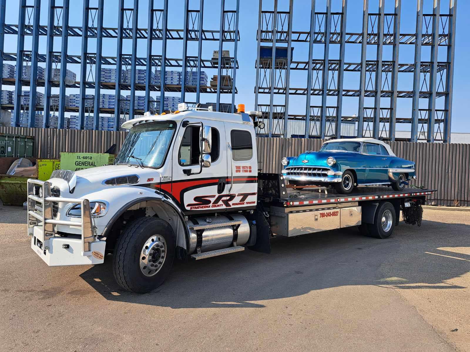 A Flatbed Truck Carrying a Blue Car