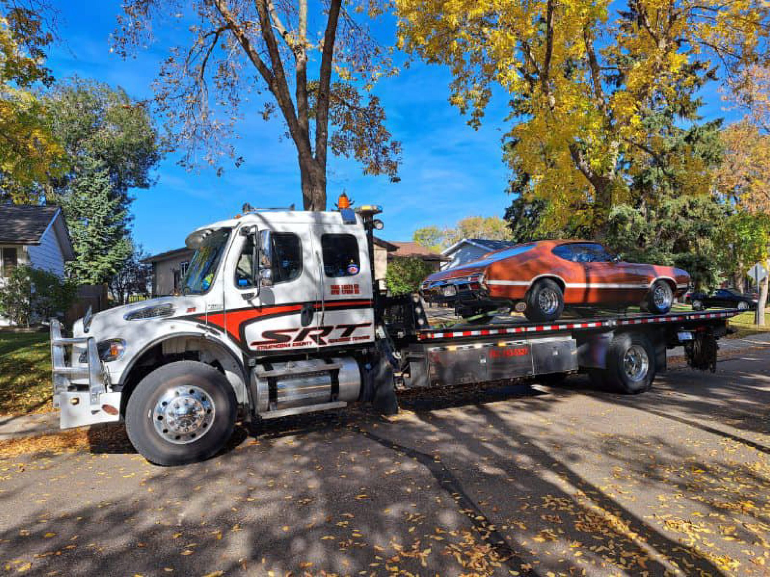 A Flatbed Truck With a Car on the Back